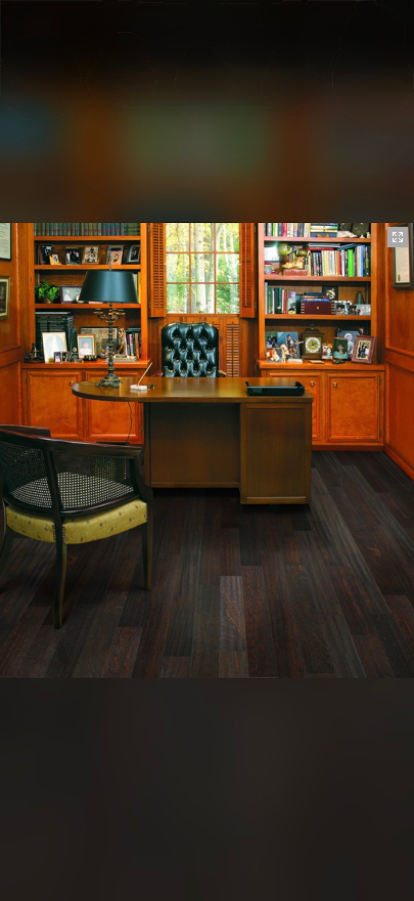 Wood paneled home office with bookshelves and hardwood floor