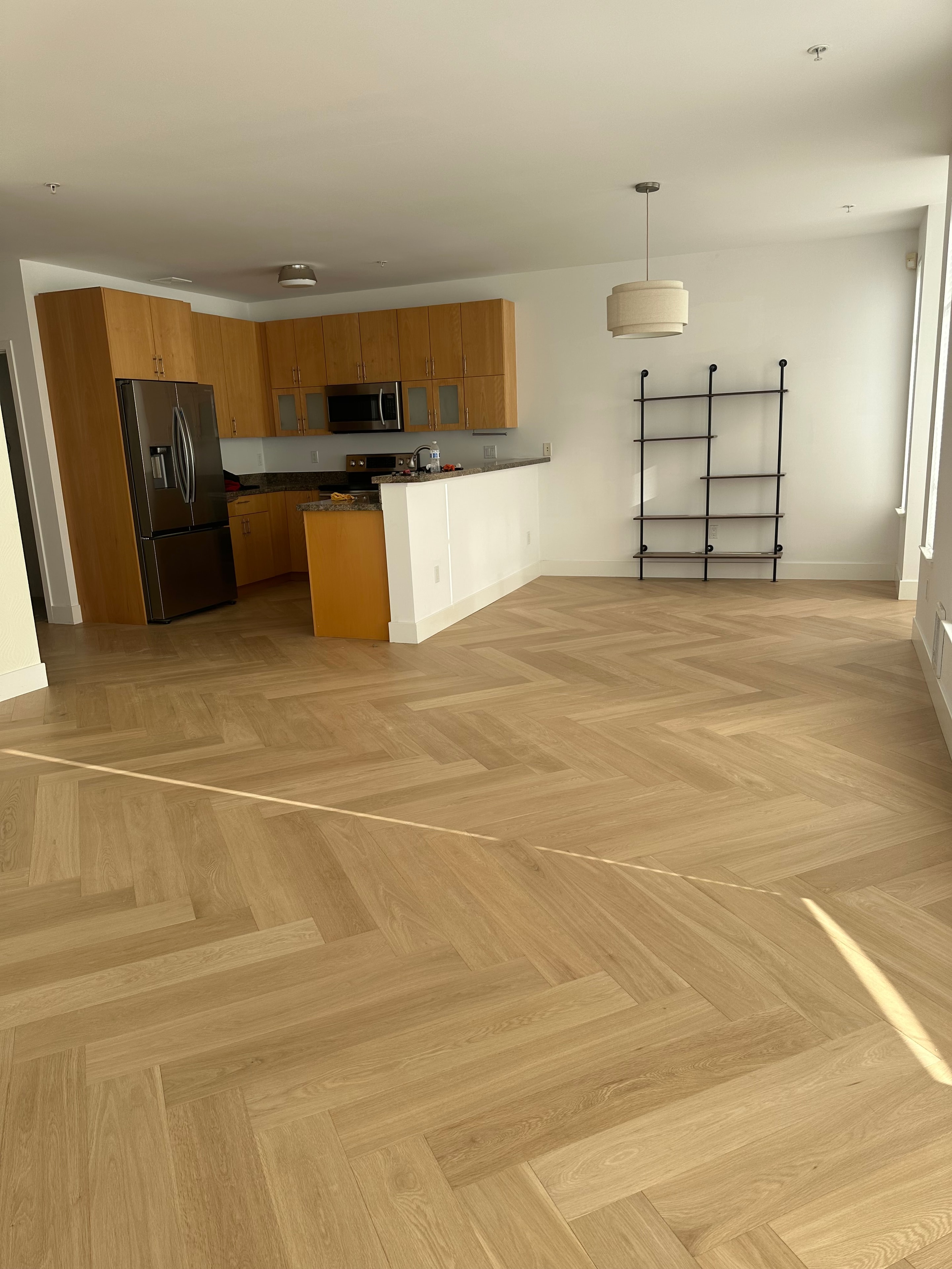 Bathroom with herringbone wood floor and warm cabinetry