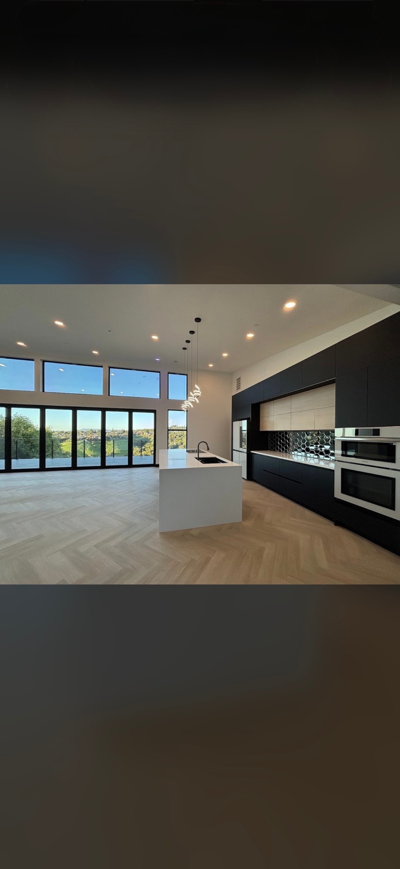 Modern kitchen with island and panoramic windows over hardwood floor