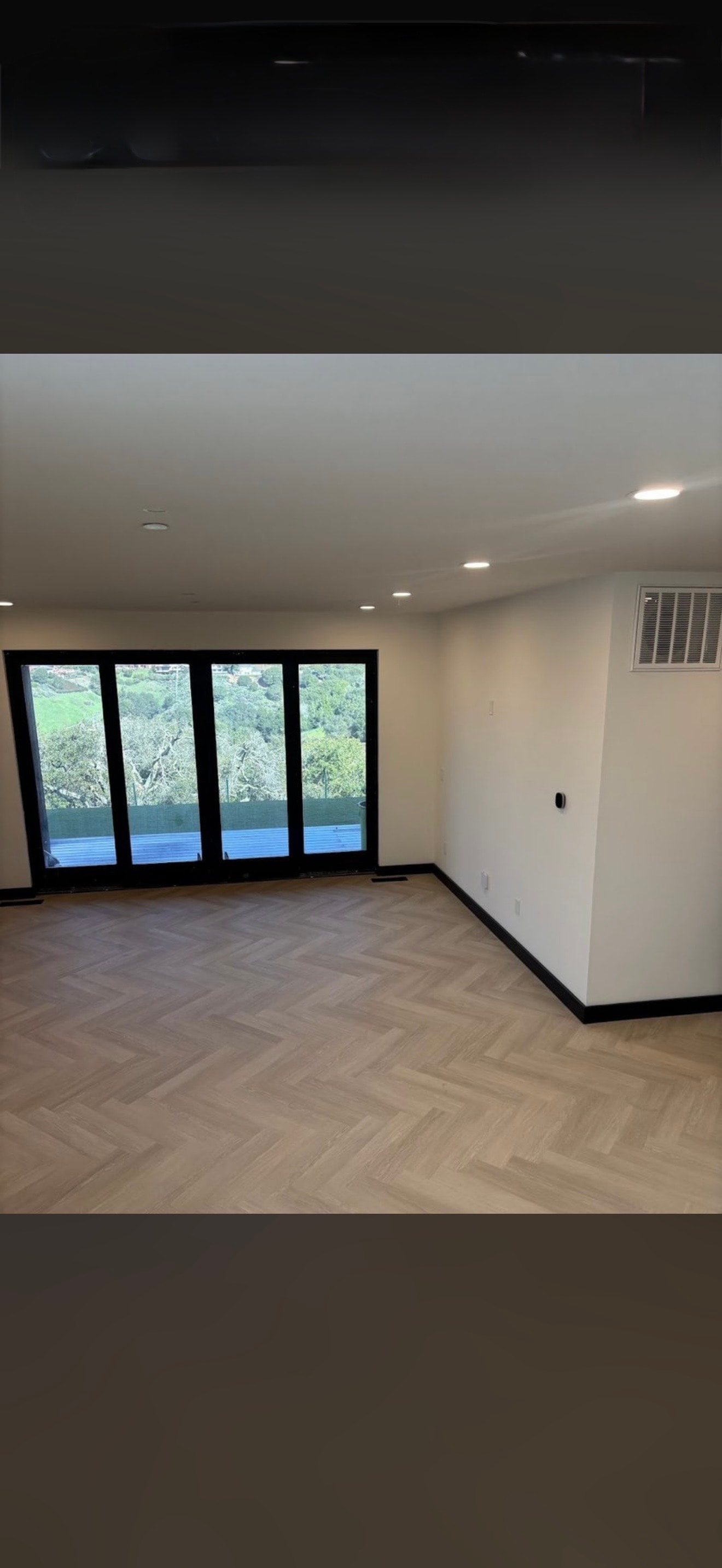 Modern room with glass doors and herringbone hardwood floor
