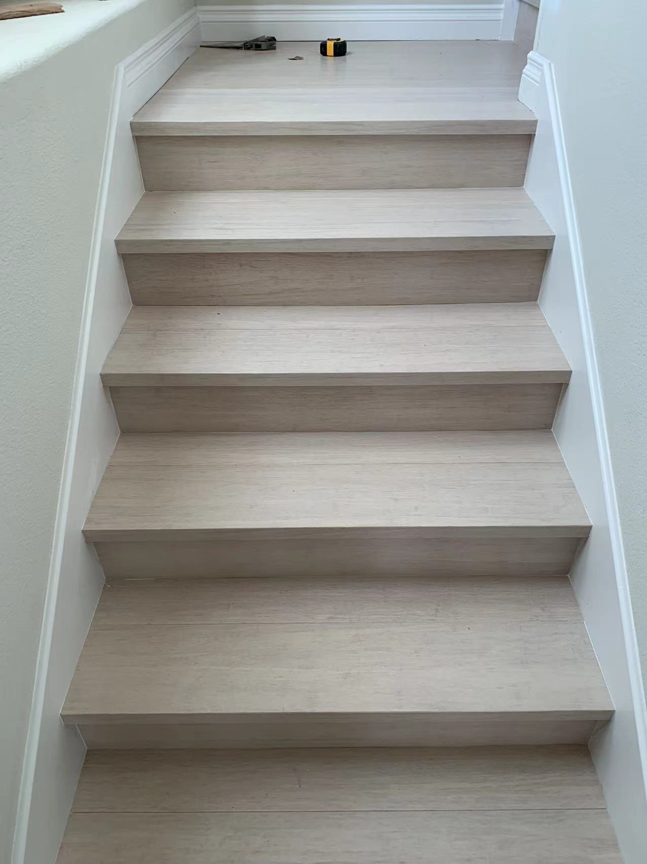 Light bleached wood staircase with white walls