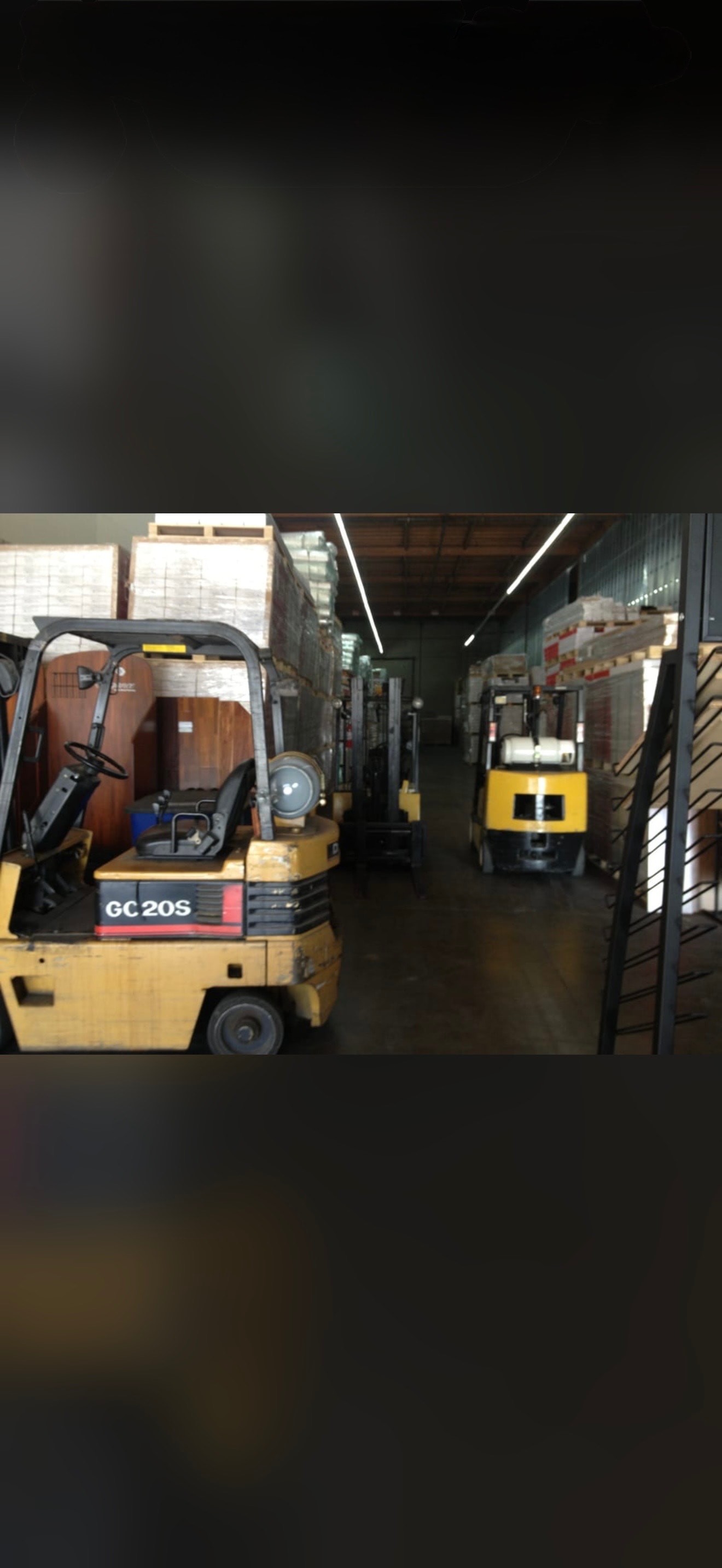 Forklifts in industrial warehouse with flooring inventory